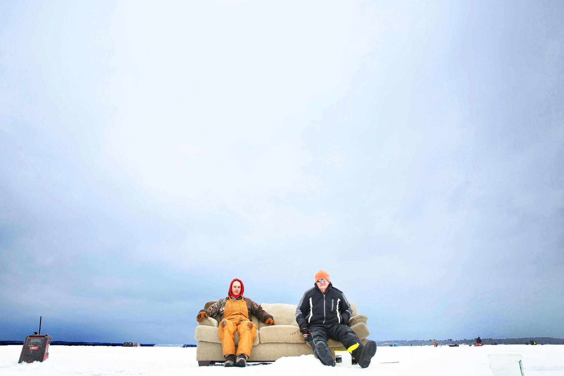 Two men sitting on a couch on the ice 