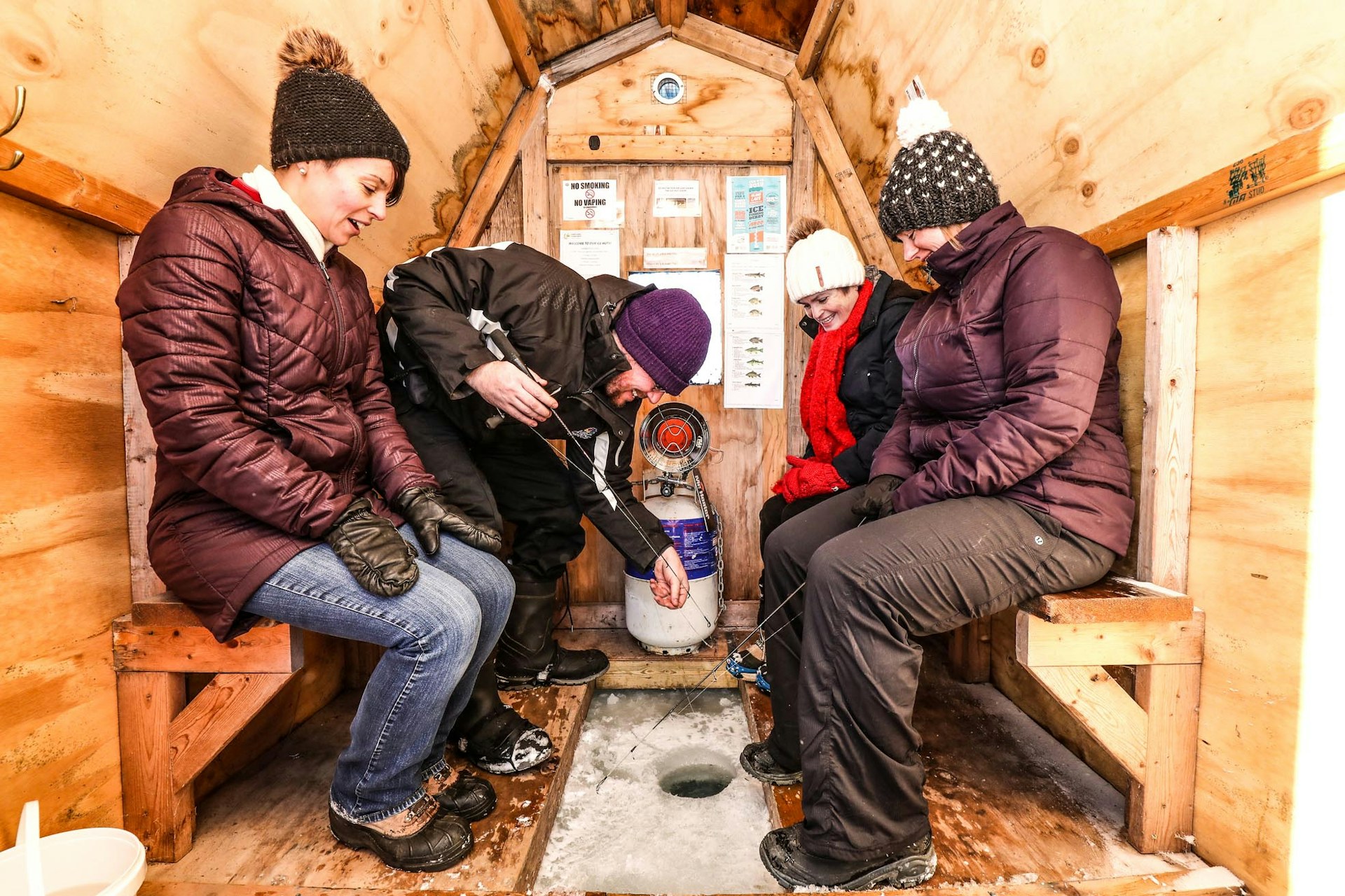 People Ice Fishing in a Hut